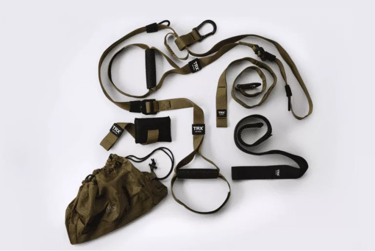 A TRX suspension training system with straps and a bag on a white surface.