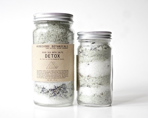 Two glass jars filled with layered Detox Bath Salts labeled “Herbivore Botanicals Detox.”.