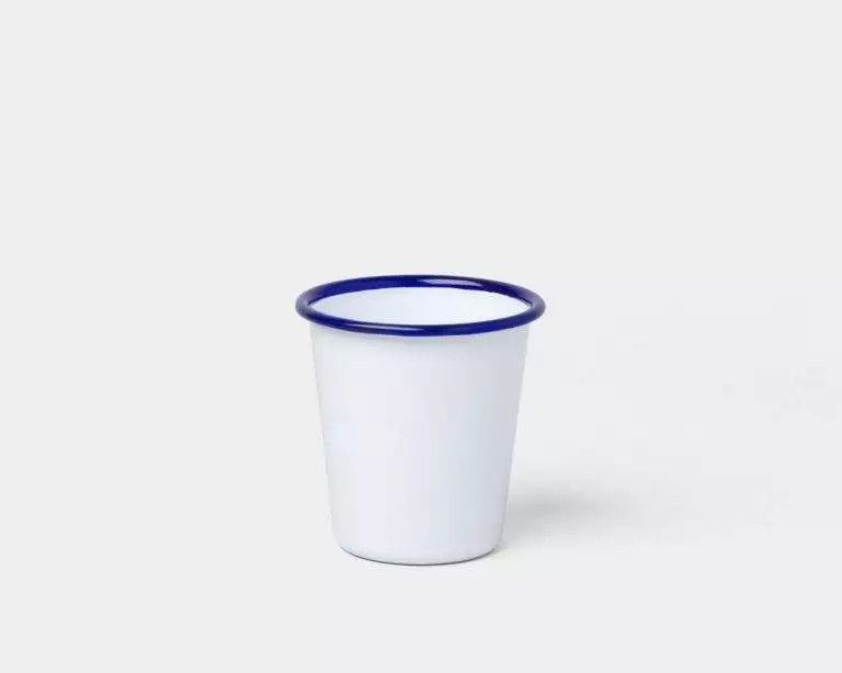 A white Falcon Enamelware cup on a white surface.